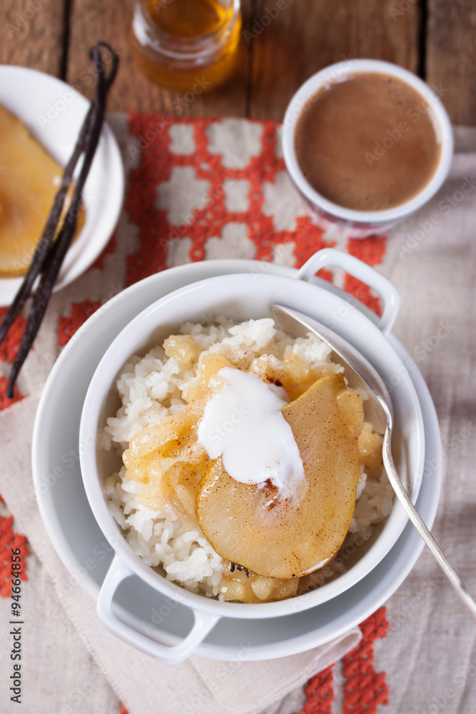 Rice with milk, cinnamon and pear with honey in a white bowl. Top view. Rice with milk, cinnamon and pear with honey in a white bowl. Top view.