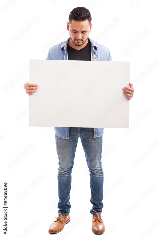 Hispanic guy holding a white sign Hispanic guy holding a white sign