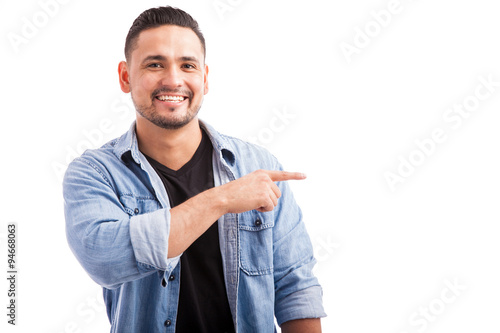 Handsome man pointing to copy space photo