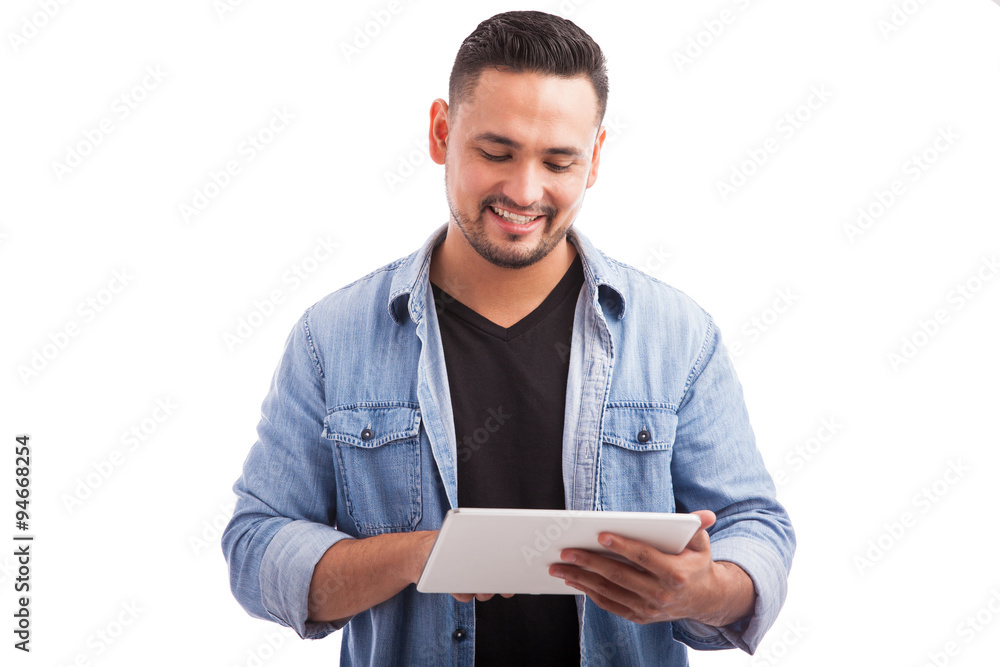 Latin guy using a tablet computer Latin guy using a tablet computer