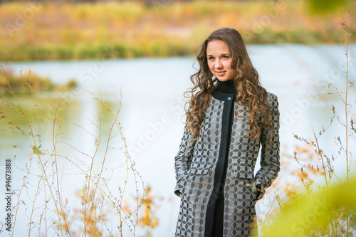 Portrait of a young girl on a background of the autumn river
