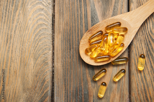fish oil capsules in a spoon