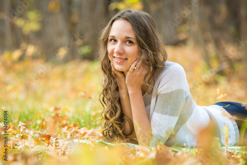 Young beautiful girl lies on the weave at a picnic in the autumn forest