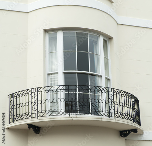 Bow window with narrow balcony set on a white building