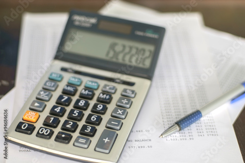 Calculator/Calculator with business accounting on wood table. 