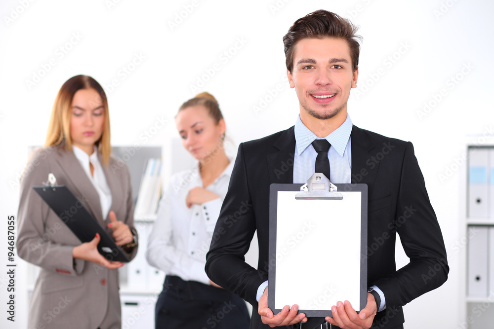 Cheerful business man in office with colleagues in the background, sturt up team Cheerful business man in office with colleagues in the background, sturt up team
