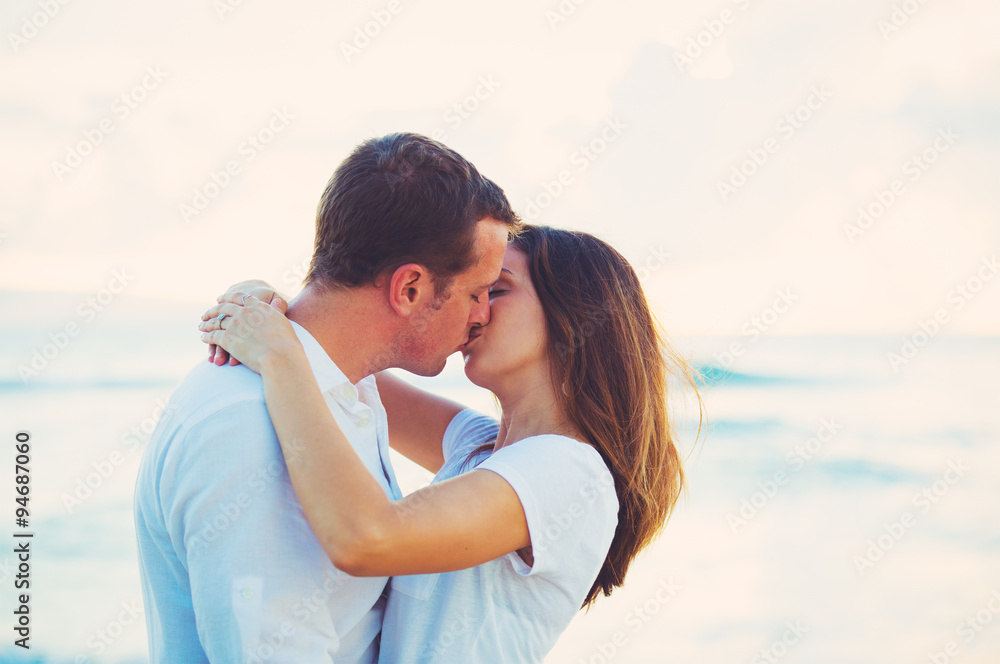 Young Couple Kissing on the Beach at Sunset Young Couple Kissing on the Beach at Sunset