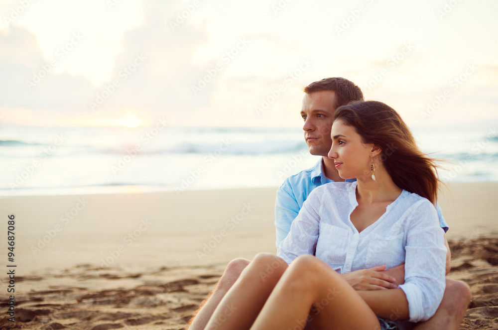 Couple Relaxing on the Beach Watching the Sunset