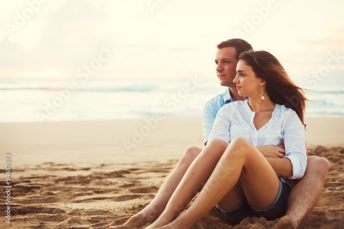 Couple Relaxing on the Beach Watching the Sunset © EpicStockMedia