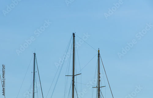 close view of the modern ship masts and ropes in front of a clear blue sky