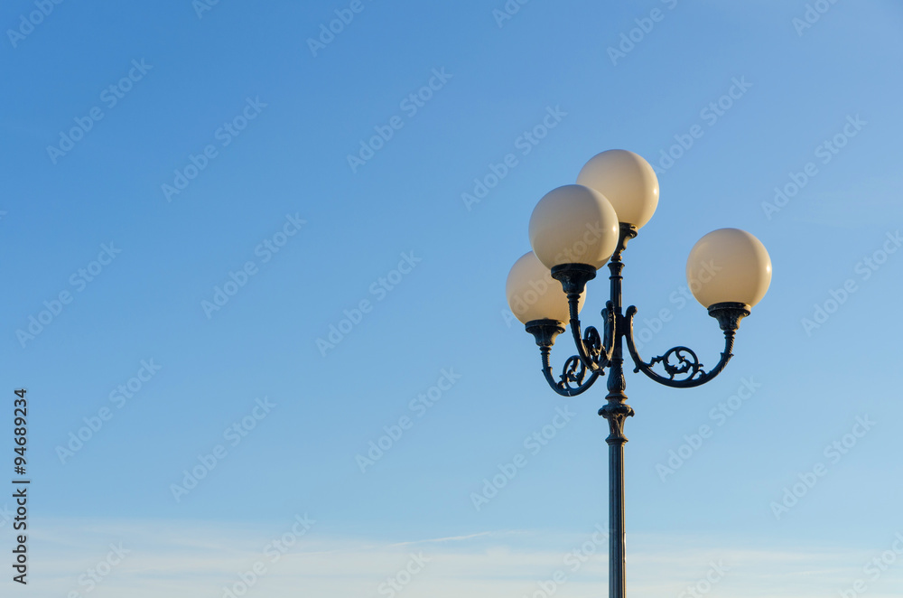 vintage lamp post in front of  blue sky on a sunny day