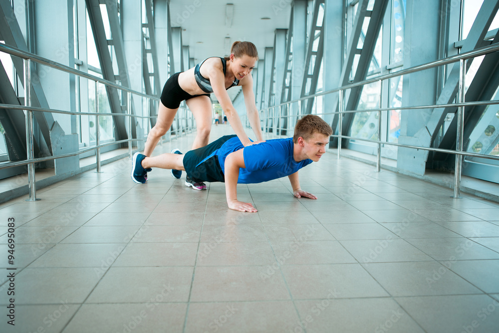 young man and woman doing exercises in the modern bridge construction young man and woman doing exercises in the modern bridge construction