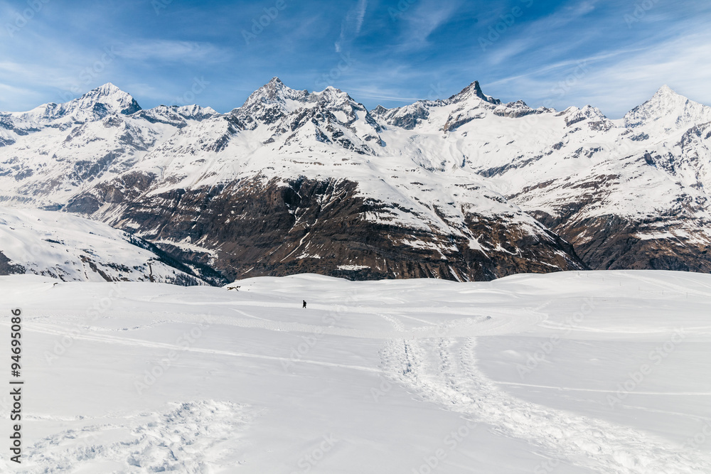 Man walking on the snow with the background of snow mountain. Man walking on the snow with the background of snow mountain.