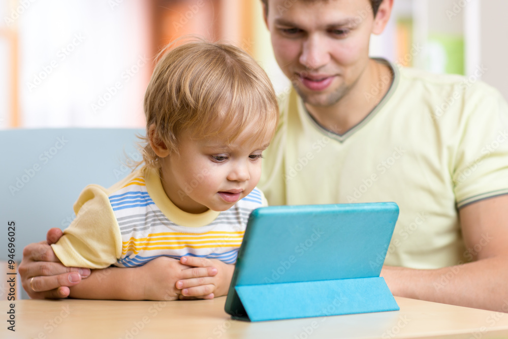father and son kid play with tablet computer indoors father and son kid play with tablet computer indoors