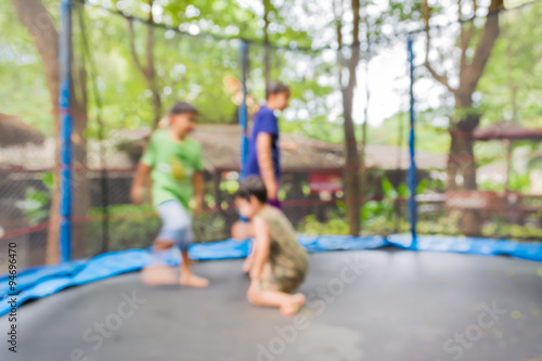 blur image of kid jumping in trampoline on day time
