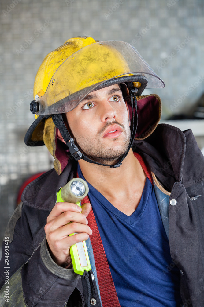 Firefighter Holding Torch At Fire Station Firefighter Holding Torch At Fire Station