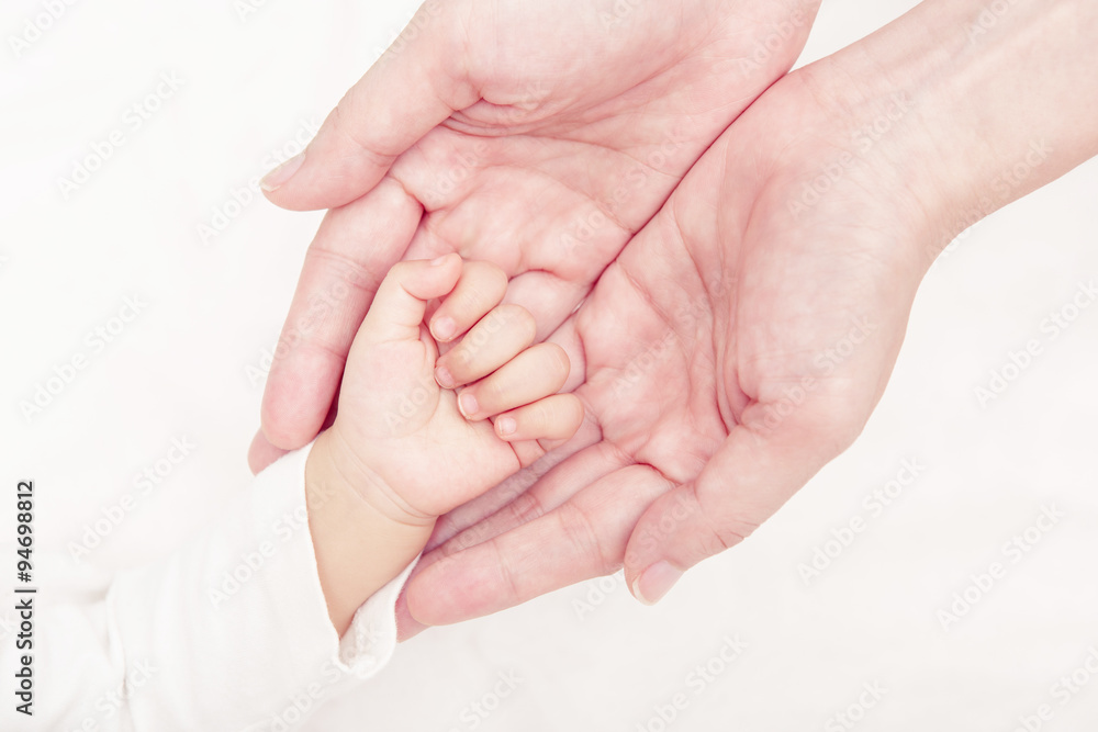 Hand the sleeping baby in the hand of mother close-up (Soft focu Hand the sleeping baby in the hand of mother close-up (Soft focu