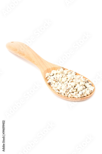 Job's tears with wooden spoon isolated on white.