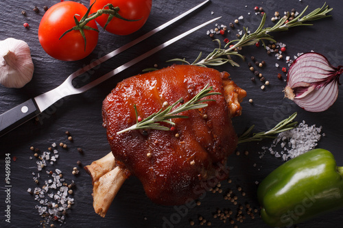 Baked pork knuckle, vegetables and spices close-up. Horizontal top view
 photo