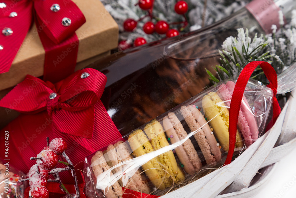christmas present in basket with  pastry, wine, decor