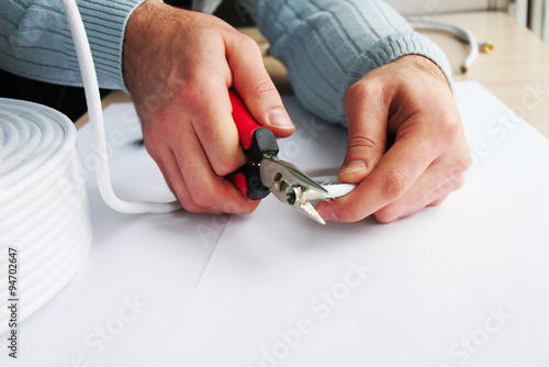 Coaxial Cable to Transmit TV Satellite Signals in Worker Hands. Closeup Cable Repair. photo