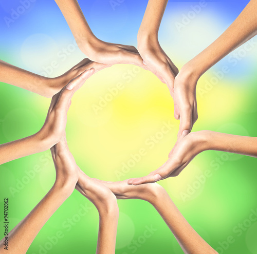 group of young people's hands over bright nature background