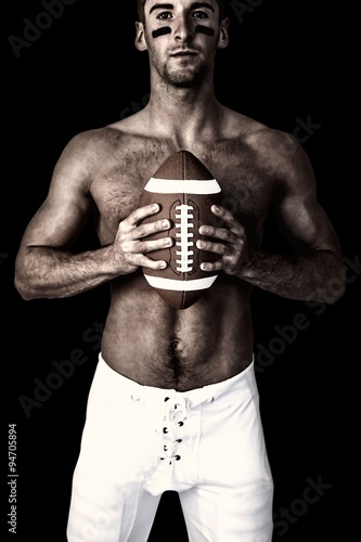Composite image of shirtless player holding rugby ball