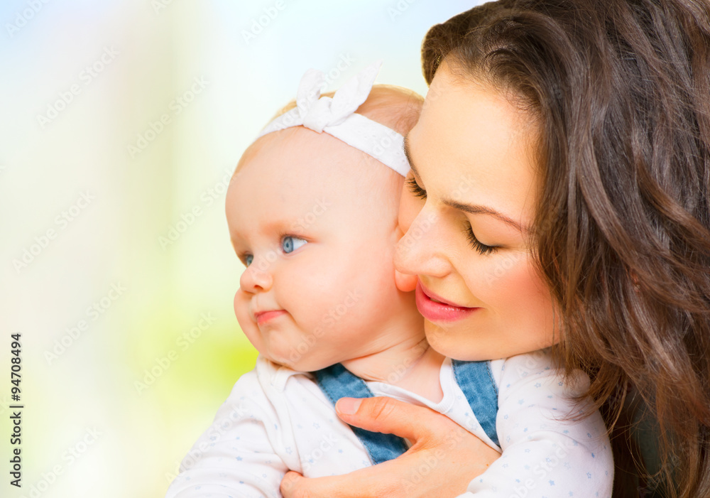 Happy family. Mom and baby girl kissing and hugging at home Happy family. Mom and baby girl kissing and hugging at home