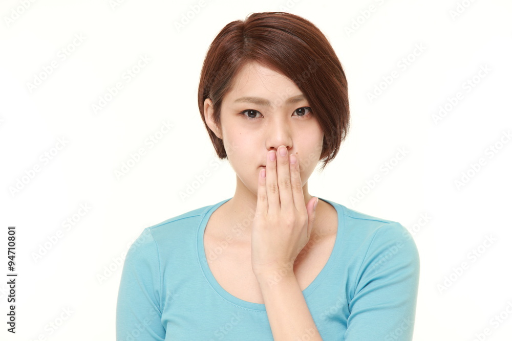 Japanese woman making the speak no evil gesture Japanese woman making the speak no evil gesture