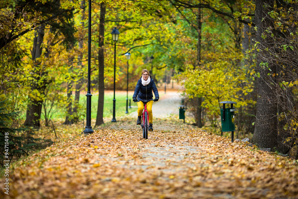 Obraz premium Urban biking - woman riding bike in city park 