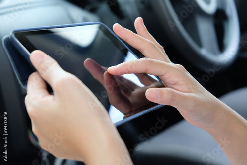 Business technology concept.Woman Sitting in the Car and Using digital tablet.