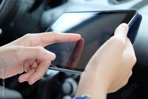 Woman Sitting in the Car and Using digital tablet.Business technology concept.