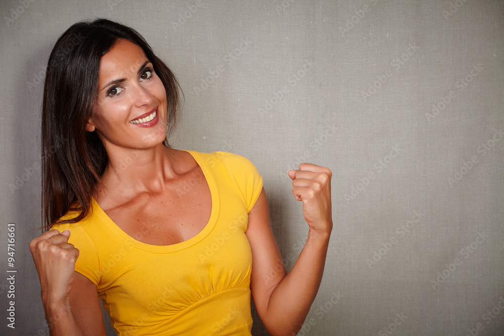 Excited woman celebrating while looking at camera Excited woman celebrating while looking at camera
