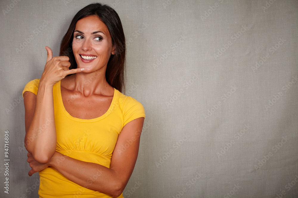 Good-looking woman gesturing a call while smiling Good-looking woman gesturing a call while smiling