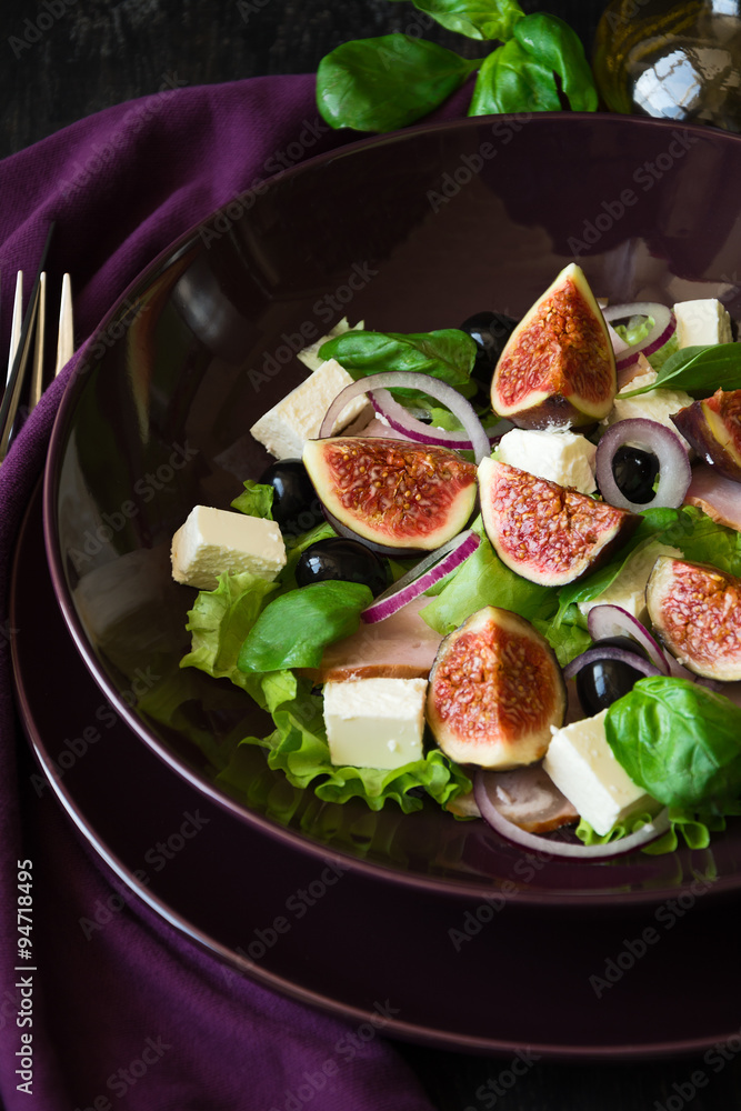 Fresh salad with Feta, ham and vegetables on purple plate