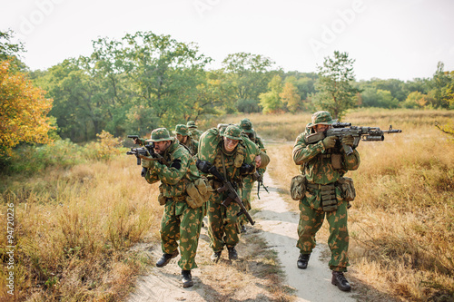 soldiers evacuate the injured fellow  in forest