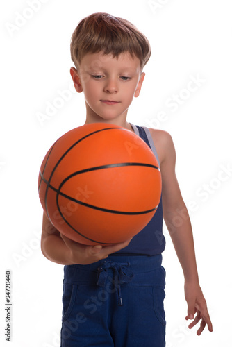 The boy held a basketball ball an one hand