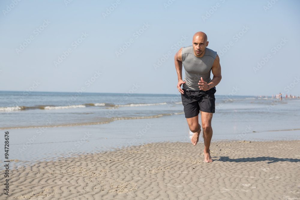 man running on a beach in summer sun
