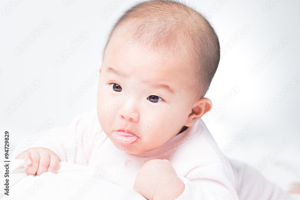 Adorable Asian baby 4-5 months old on white bed & background. Portrait studio light isolated.
