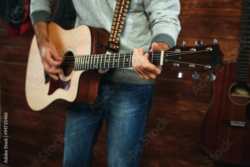 man playing guitar. Guitars on wall on background  love music concept