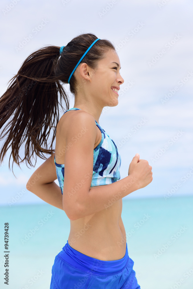 Running woman training her cardio workout in sports bra and hairband doing  exercise. Portrait of mixed