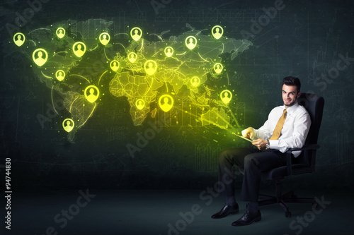 Businessman in office with tablet and social network world map