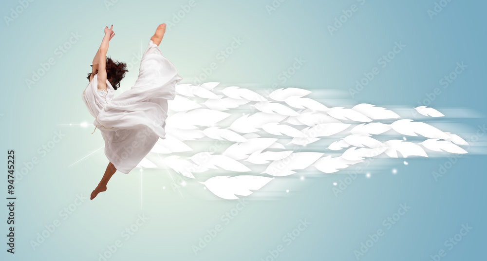 Naklejka premium Healthy young woman jumping with feathers around her