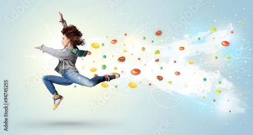 Beautiful woman jumping with colorful gems and crystals on the b