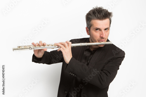 Musico tocando la flauta travesera sobre fondo blanco photo