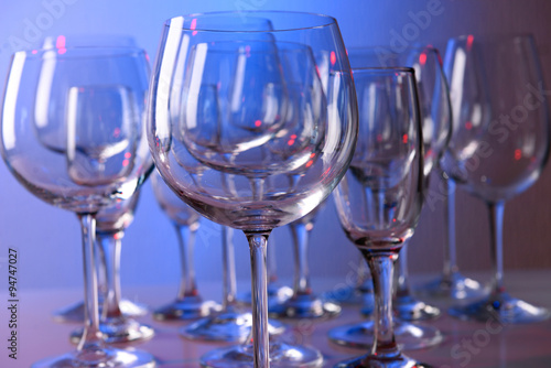 Empty wine glasses on color background