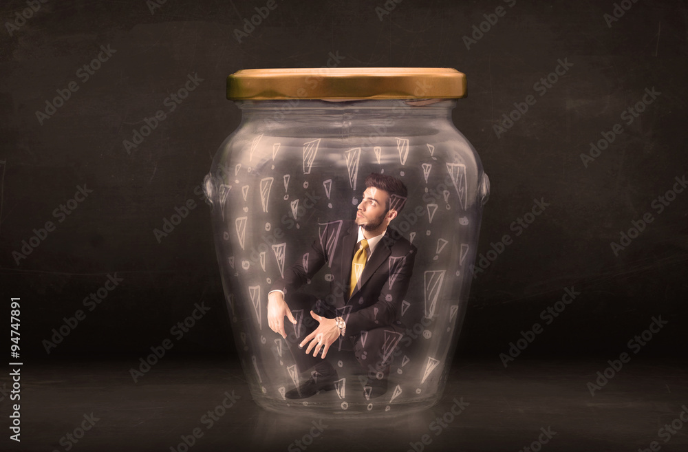 Business man trapped in jar with exclamation marks concept Business man trapped in jar with exclamation marks concept