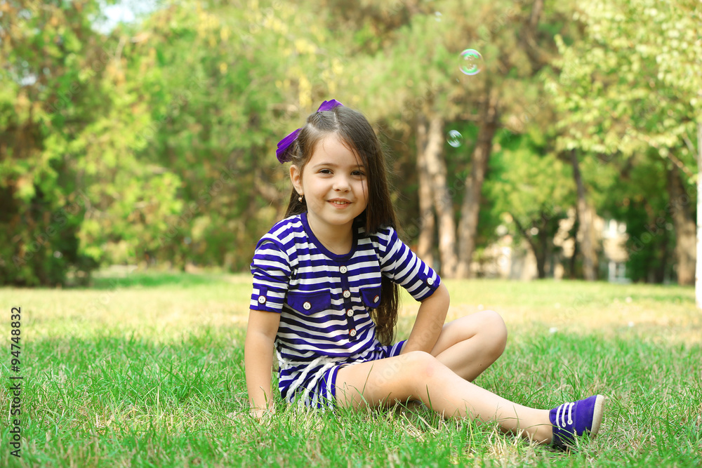 Happy little girl on the green grass in the park Happy little girl on the green grass in the park