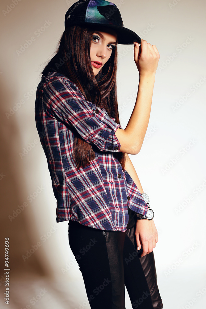 young woman with long dark hair wears casual plaid shirt and cap young woman with long dark hair wears casual plaid shirt and cap