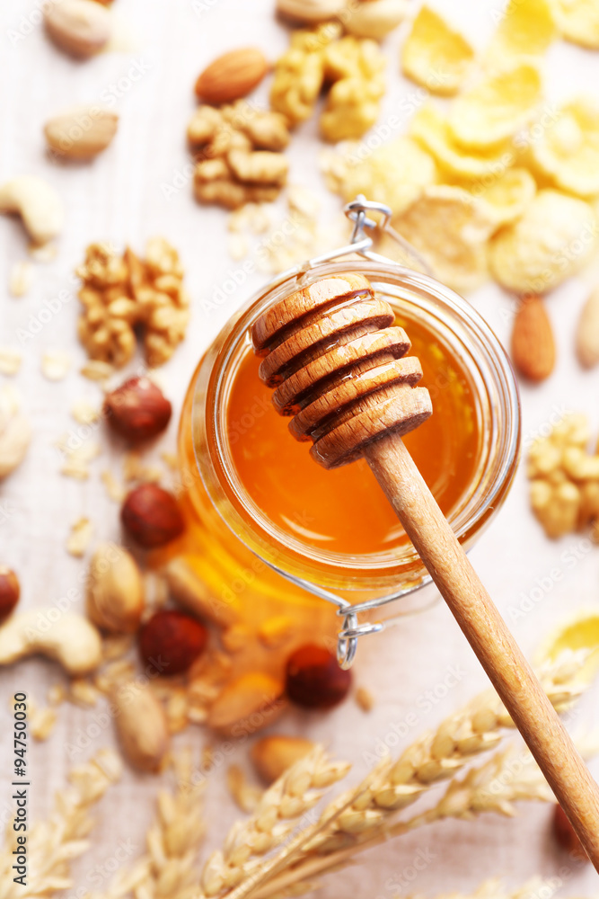 Honey in glass jar and nuts. Country breakfast concept Honey in glass jar and nuts. Country breakfast concept